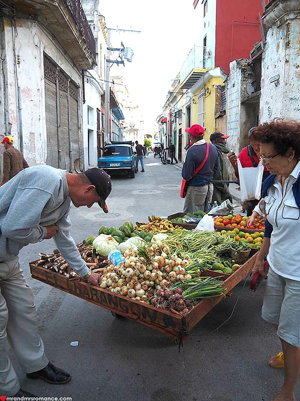 people looking at a fruit stand