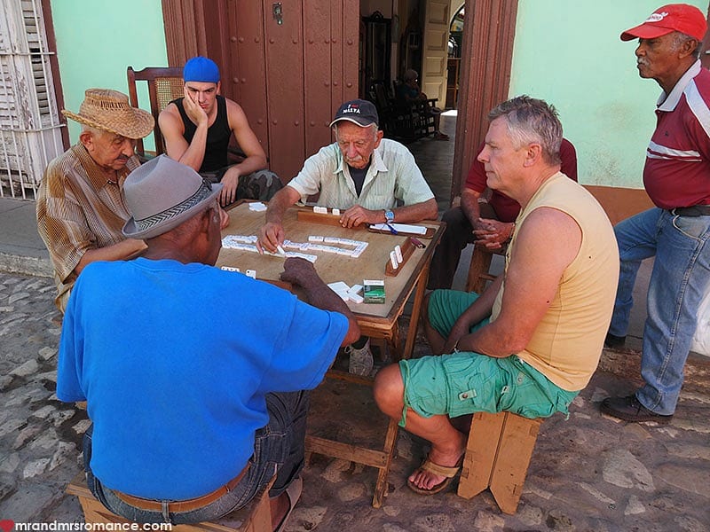 men playing dominoes at tables in cuba street