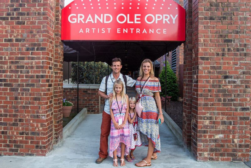 family posing in front of entrance to the Backstage tour of the Grand Ole Opry in Nashville