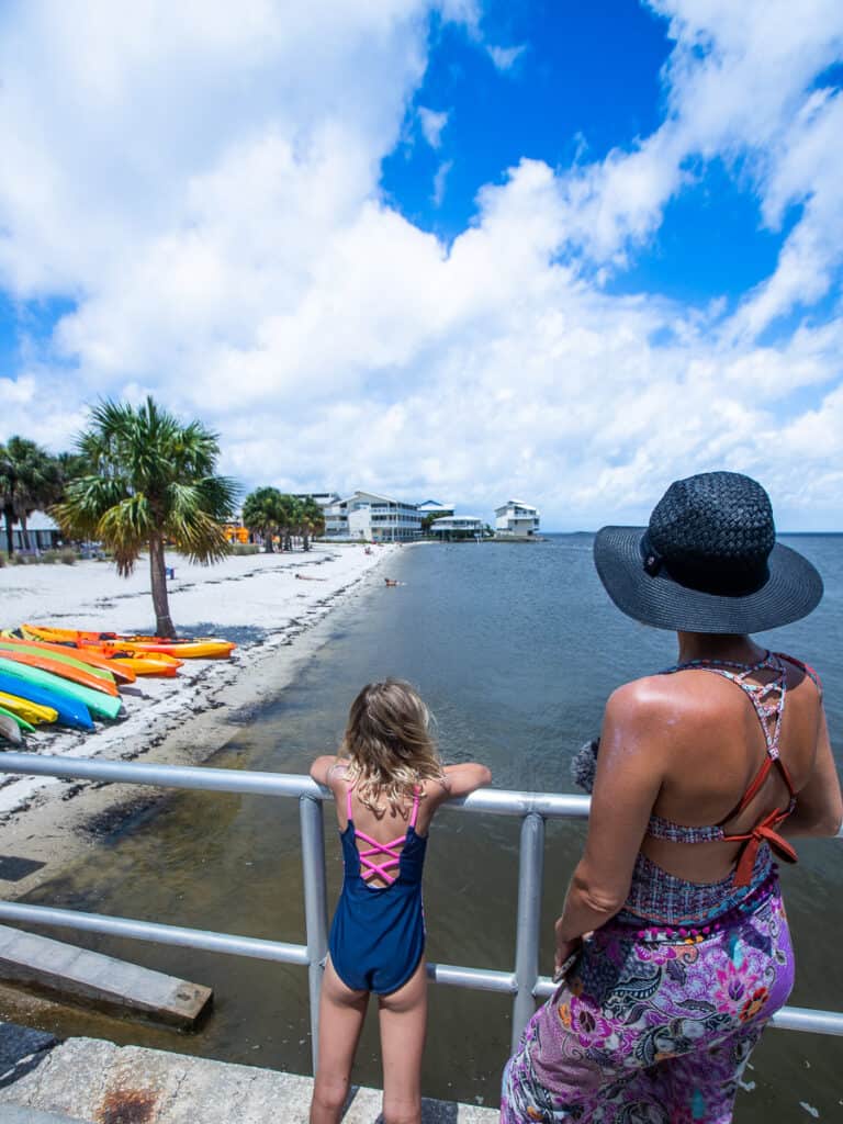 Mom and daughter looking over a beach.