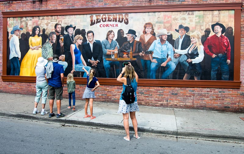 people standing in front of a wall mural