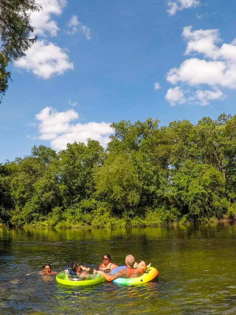 People floating on tubes in a natural spring.