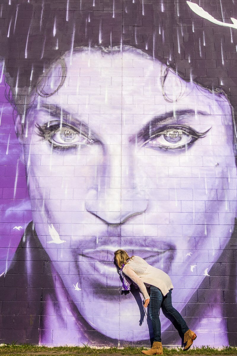 woman kissing Prince mural in Minneapolis. 