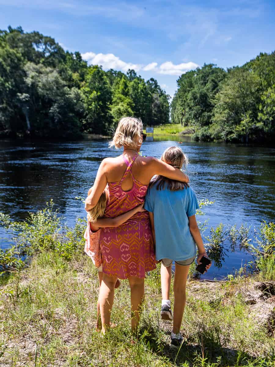 Mom and daughters by a river.