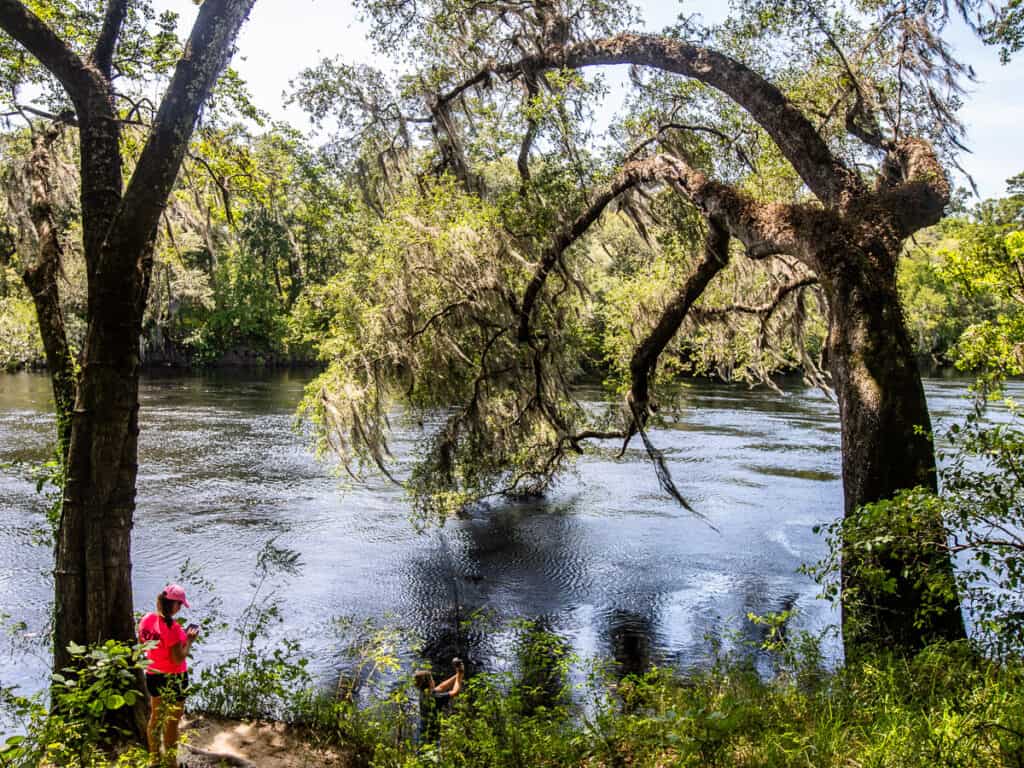 Lady standing at a rivers edge.