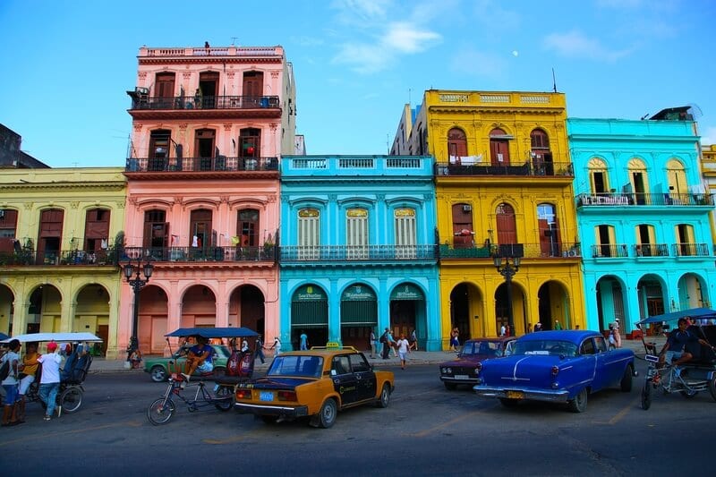 cars in front of colorful buildings in havana 