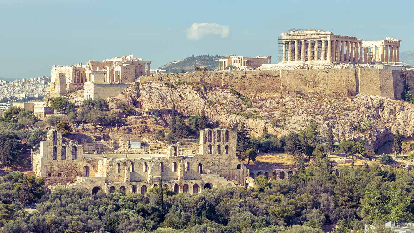 The ancient Acropolis of Athens, Greece, with the Parthenon temple visible on a sunlit day against a clear sky